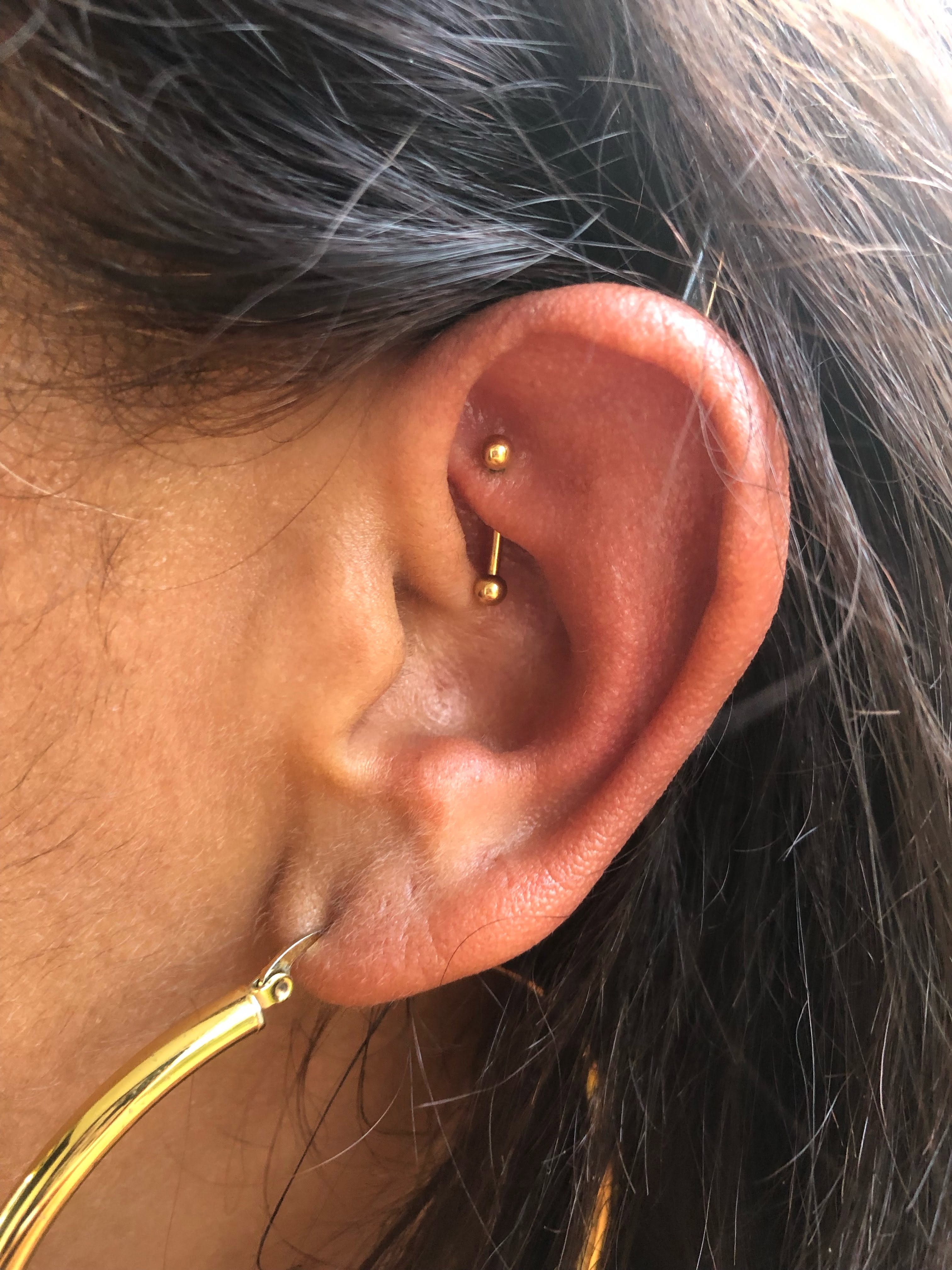 Bijou doré dans le cartilage de l’oreille, vu de profil